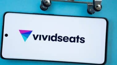 Smartphone screen showing the VividSeats logo with shopping cart wheels on a blue background.