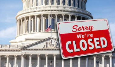 The US Capitol with a closed sign hanging from the dome.