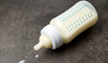 Baby milk bottle on dark grey table