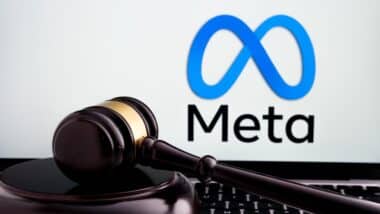 Court gavel placed on laptop with blurred Meta Platforms company logo on the screen.