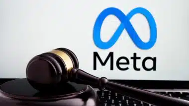 Court gavel placed on laptop with blurred Meta Platforms company logo on the screen.