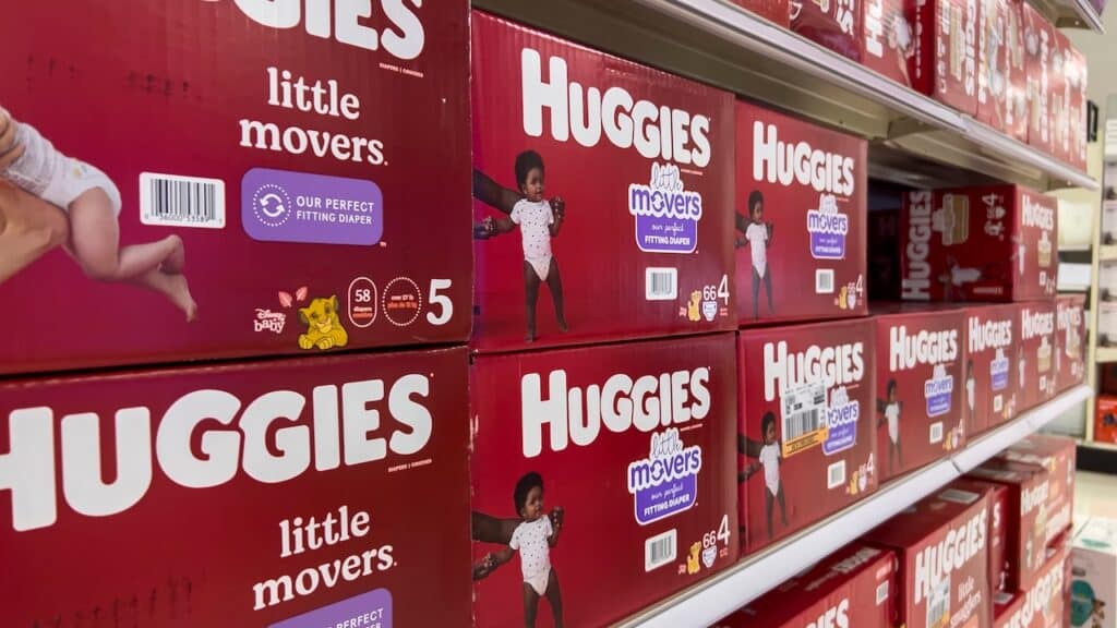 Angled, selective focus on baby diapers and training pants for sale inside a retail store.