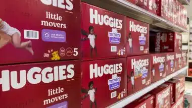 Angled, selective focus on baby diapers and training pants for sale inside a retail store.