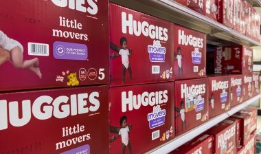 Angled, selective focus on baby diapers and training pants for sale inside a retail store.