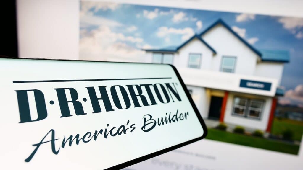 Smartphone with logo of American home construction company D.R. Horton Inc. on screen in front of website.
