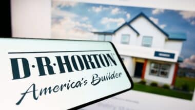 Smartphone with logo of American home construction company D.R. Horton Inc. on screen in front of website.