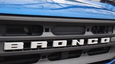 close up shot of the grille of a blue Ford Bronco