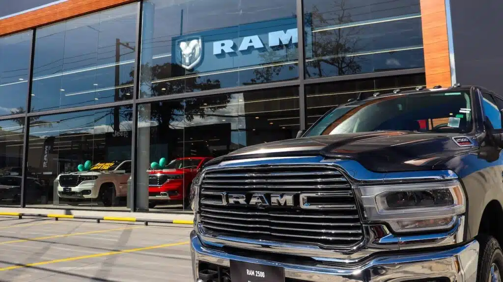 RAM pickup truck parked in front of RAM dealership on a sunny day