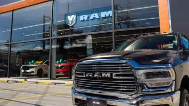 RAM pickup truck parked in front of RAM dealership on a sunny day