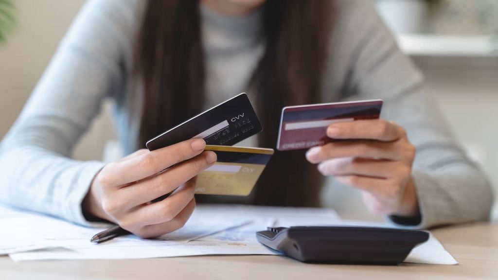 hand of woman sitting, holding credit card, stressed