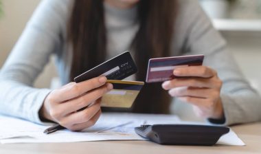 hand of woman sitting, holding credit card, stressed