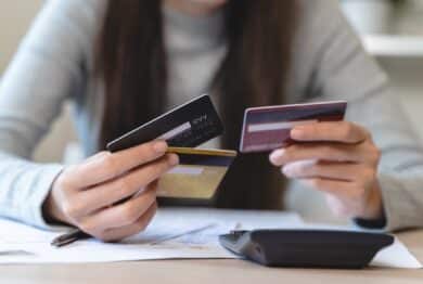 hand of woman sitting, holding credit card, stressed