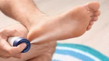 Man using foot spray at home