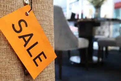 A yellow SALE tag on the sofa, with blurred furniture in the background