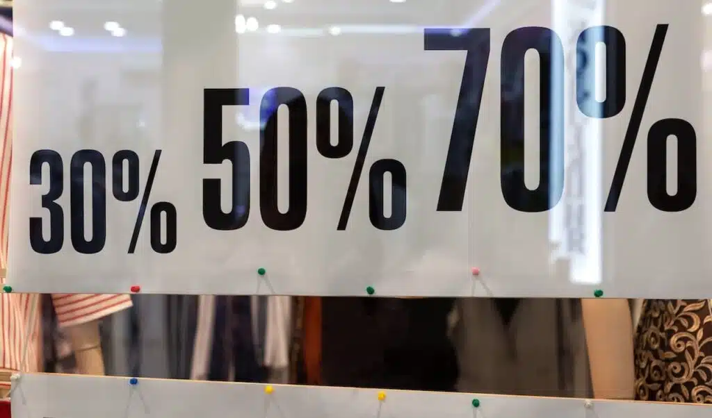 Showcase of clothing store in season of discounts, banner with inscriptions of discount sizes, 30, 50, 70 percent. Concept shopping, discounts.