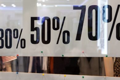 Showcase of clothing store in season of discounts, banner with inscriptions of discount sizes, 30, 50, 70 percent. Concept shopping, discounts.