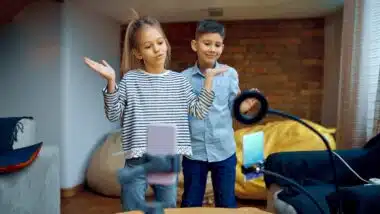 Cheerful children tiktokers dance on camera