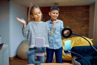 Cheerful children tiktokers dance on camera