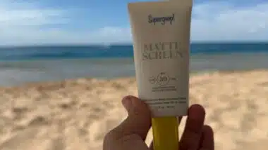 A bottle of Glow Recipe Tinted Serum and Supergoop Tinted Sunscreen at the Beach