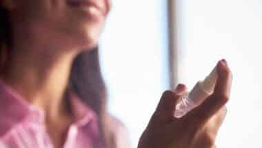 woman spraying facial mist onto skin during skincare routine