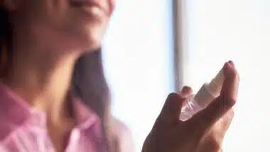 woman spraying facial mist onto skin during skincare routine
