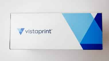 Cardboard box of Vistaprint business cards isolated on white background