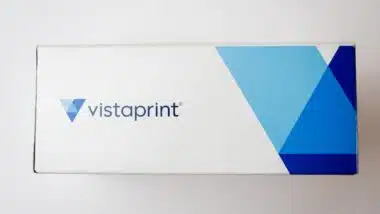 Cardboard box of Vistaprint business cards isolated on white background