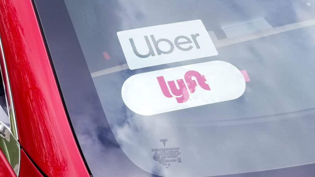 car with Uber and Lyftt ride-sharing sticker placards in the windshield.