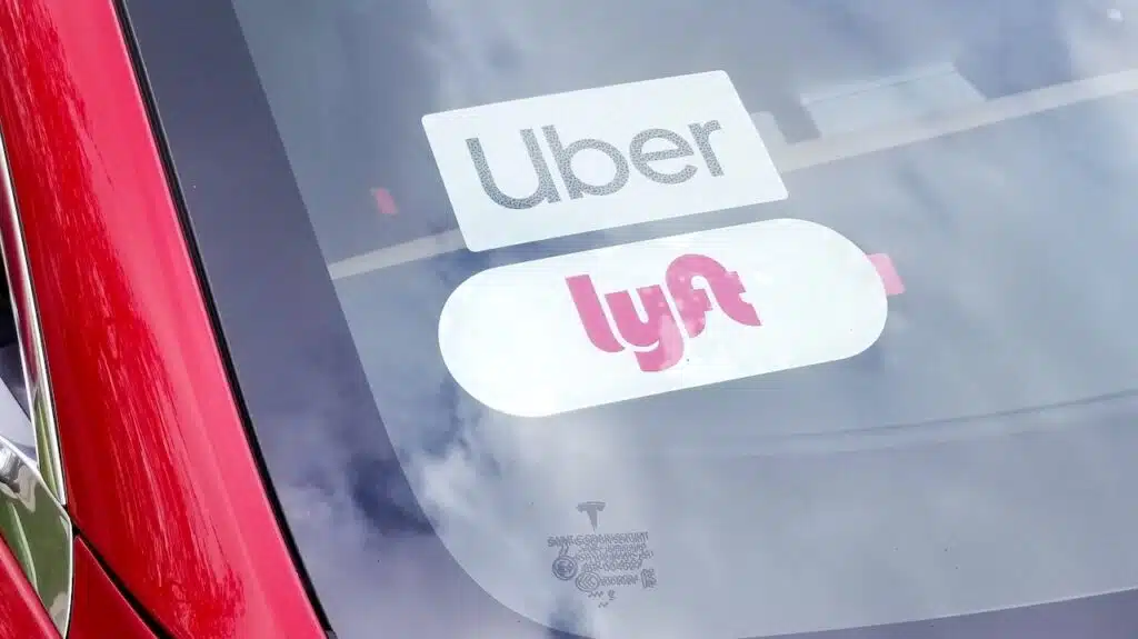 car with Uber and Lyftt ride-sharing sticker placards in the windshield.