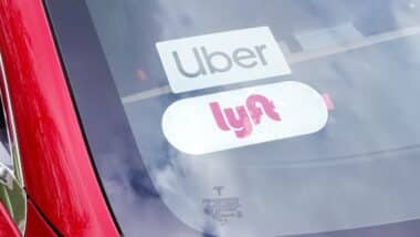 car with Uber and Lyftt ride-sharing sticker placards in the windshield.