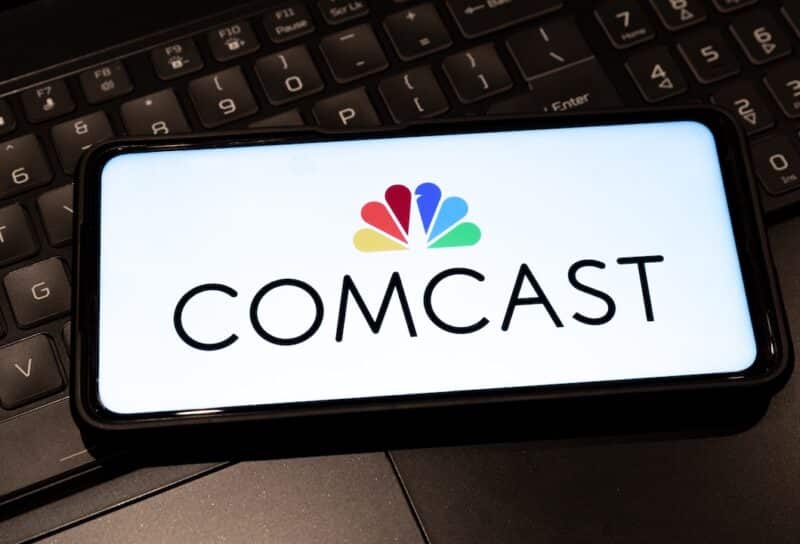 Comcast logo on mobile phone , background is a keyboard
