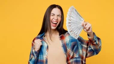 Young happy fun woman wear blue shirt beige t-shirt hold in hand fan of cash money in dollar banknotes