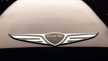 Genesis car hood or bonnet emblem or badge on a sedan displayed in showroom