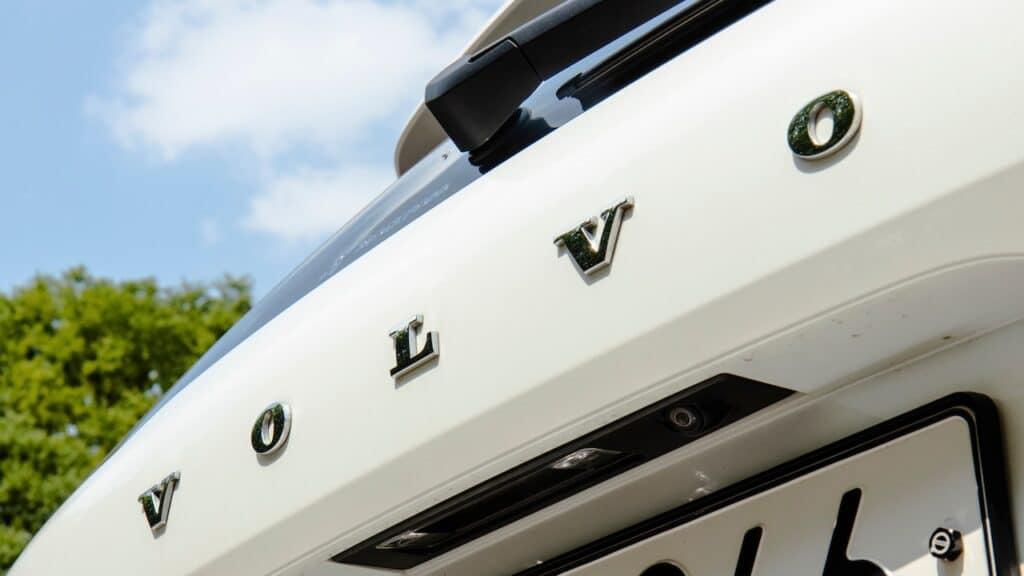 A close-up of the rear of a white Volvo XC60 showing the brand lettering and rearview camera.