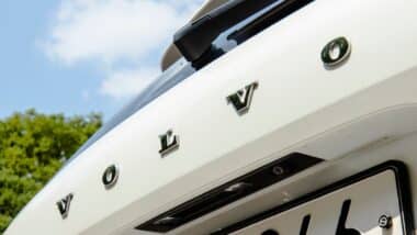 A close-up of the rear of a white Volvo XC60 showing the brand lettering and rearview camera.