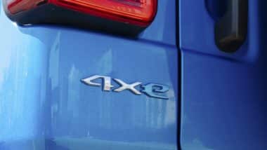 A detailed view of the '4xe' badge on a blue Jeep Wrangler