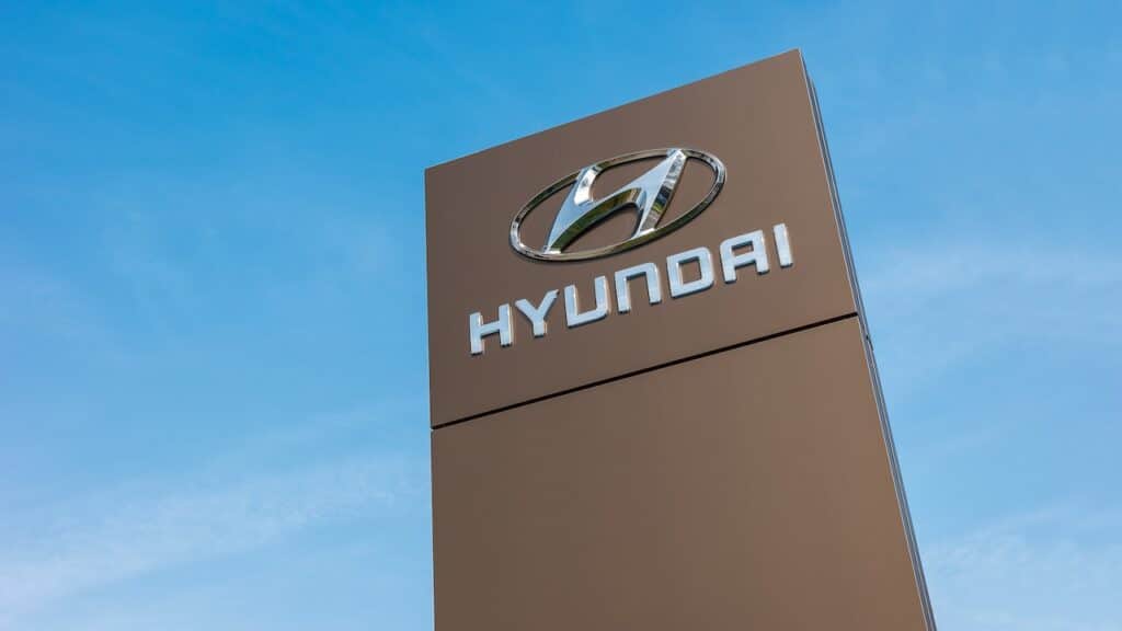 Logotype of Hyundai corporation on pillar against blue Sky.