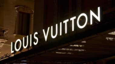 Illuminated Louis Vuitton signage suspended over a store