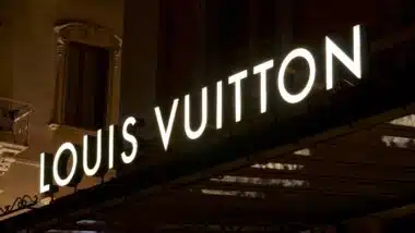 Illuminated Louis Vuitton signage suspended over a store