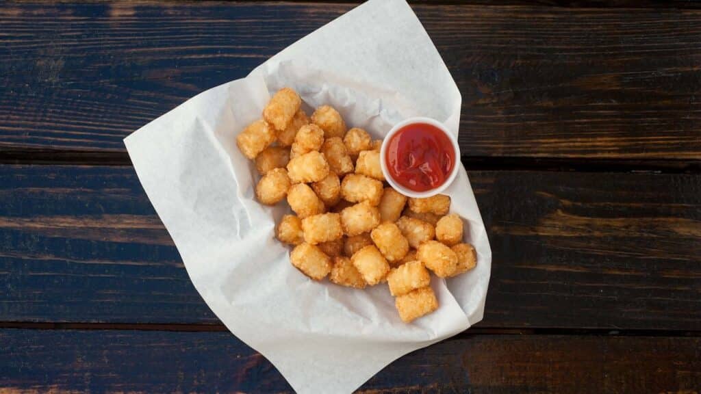 tater tots with ketchup in isolated background