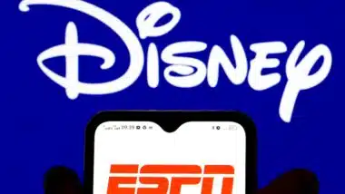 he ESPN PPV logo is displayed on a smartphone screen with the Disney logo in the background