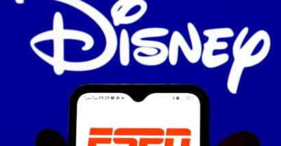 he ESPN PPV logo is displayed on a smartphone screen with the Disney logo in the background