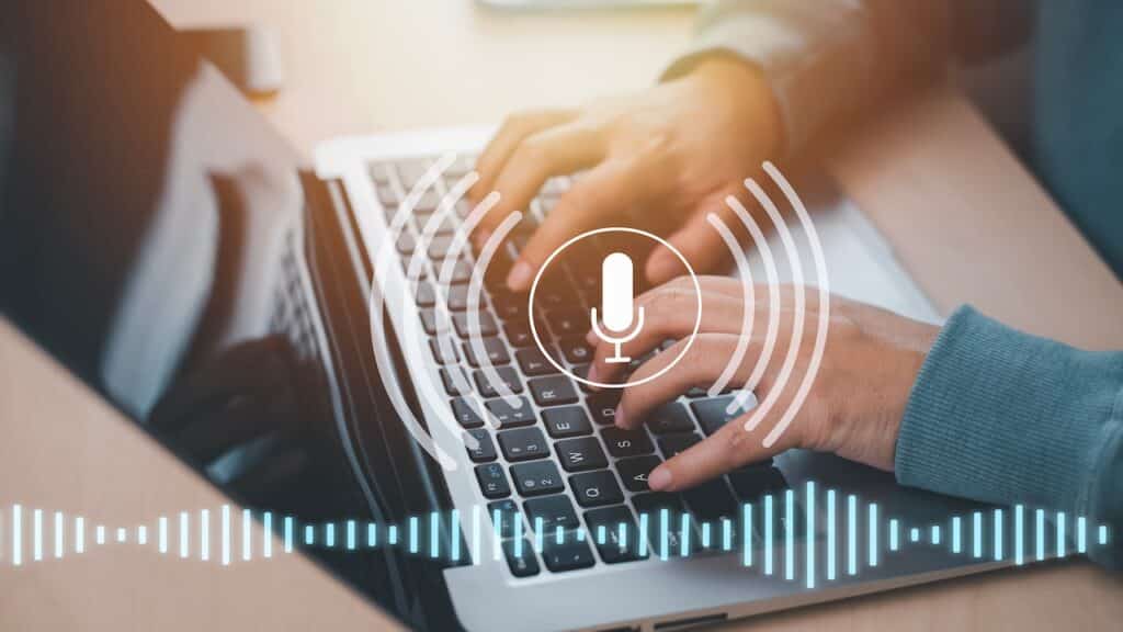 Businessman using laptop with microphone button on virtual screen.