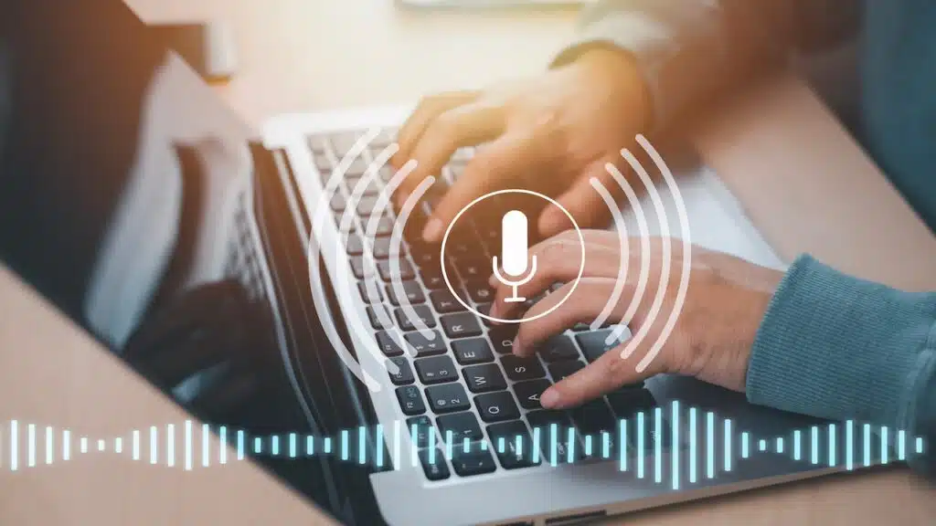 Businessman using laptop with microphone button on virtual screen.