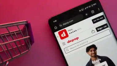 A smartphone displaying the Depop website with a shopping cart is shown on a vibrant background.