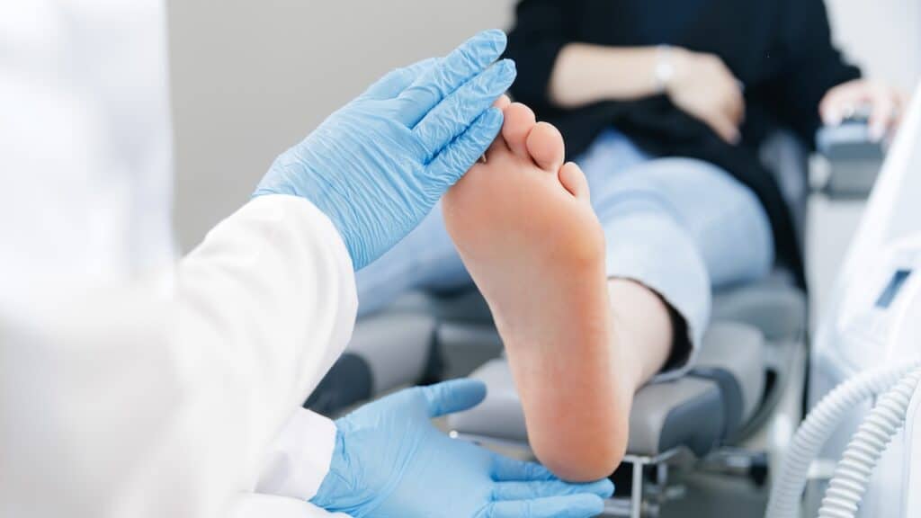 Podiatrist examining female patient foot