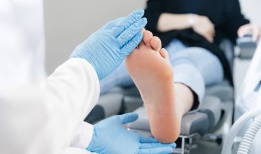 Podiatrist examining female patient foot