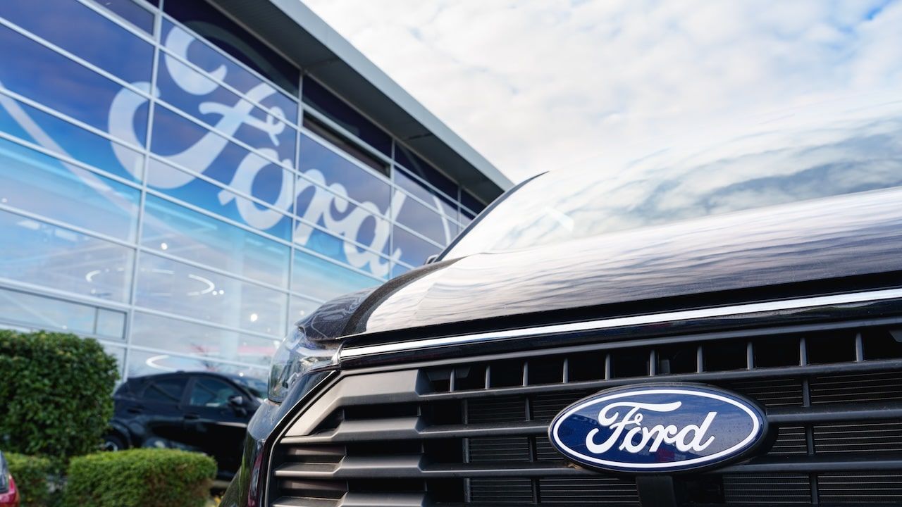 Close-up of Ford logo on car parked outside a dealership
