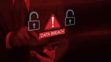 Businessman using smartphone system hacked warning alert with red open padlock icon and warning signs.