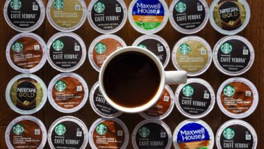 A cup of coffee on top of assorted Keurig k-cup pods.